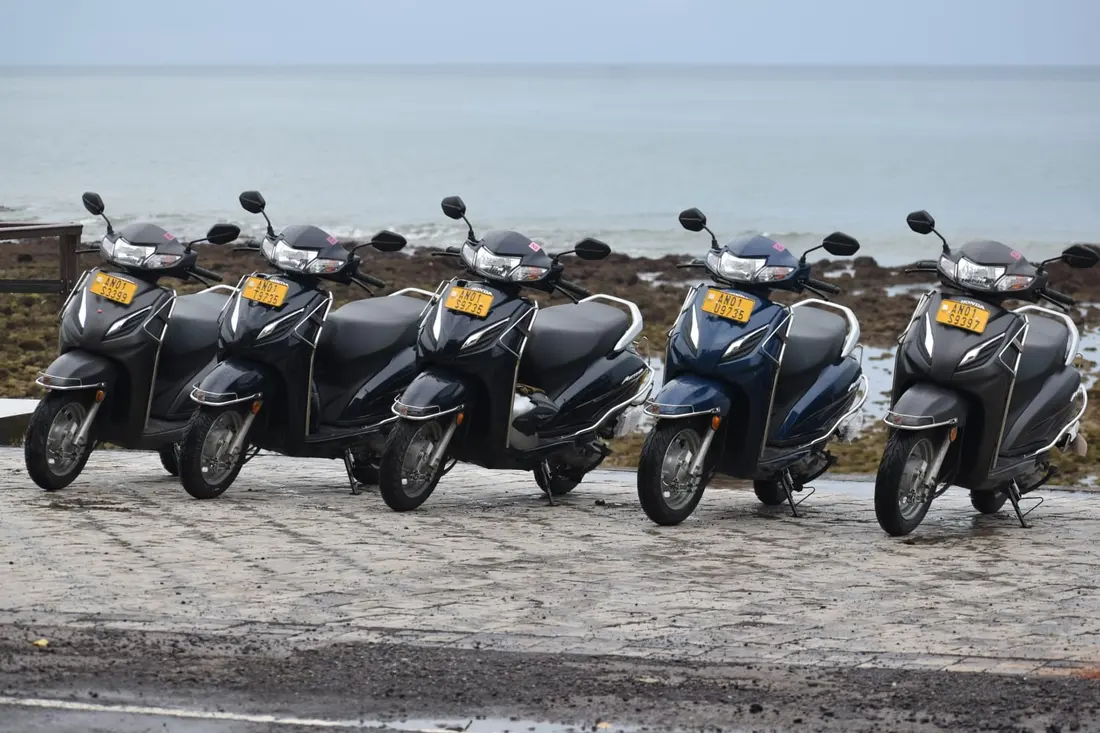 A row of rental scooters parked by the sea